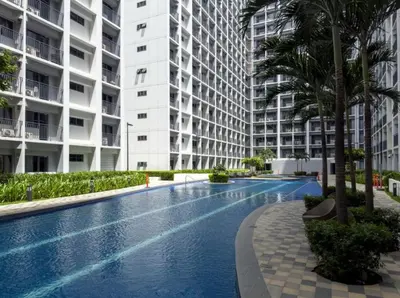 a swimming pool in front of a large apartment building at Staycation by the Shore in Manila