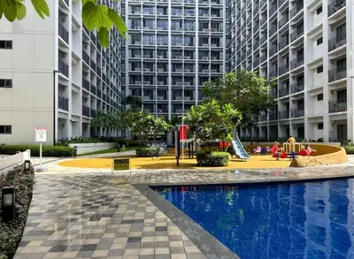 a courtyard with a playground in front of a tall building at Staycation by the Shore in Manila