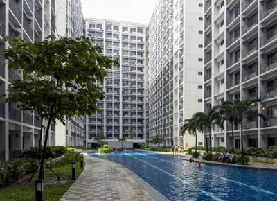a swimming pool in the middle of two tall buildings at Staycation by the Shore in Manila
