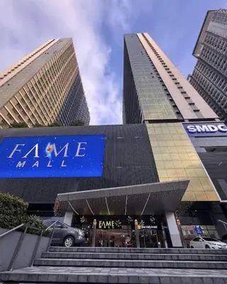 a store with a blue sign in front of two tall buildings at Relaxing City Retreat in Manila