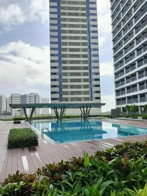 a swimming pool in the middle of two tall buildings at Relaxing City Retreat in Manila