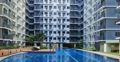 a large apartment building with a large swimming pool at Mall of Asia residence Shore 3 in Manila