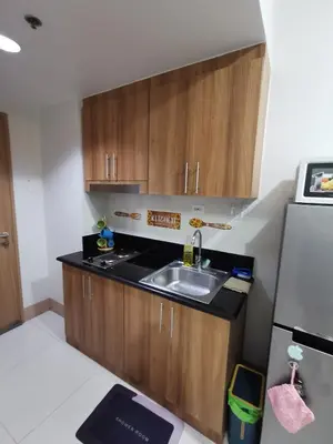 a small kitchen with a sink and a refrigerator at Mall of Asia residence Shore 3 in Manila