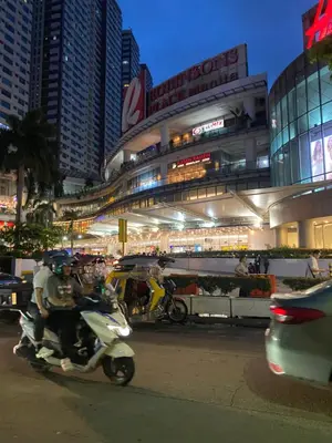 a man riding a scooter on a city street at night at JhovenD in Manila