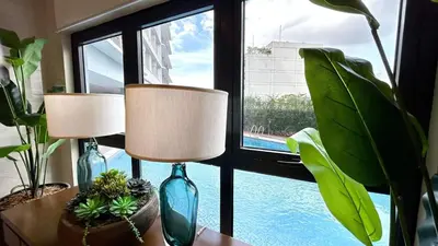two lamps on a table in front of a window at Relaxing 1BR condo with Pool and Balcony in Makati in Manila