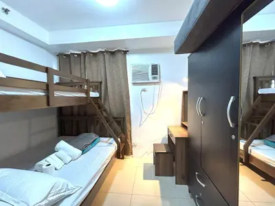 a bedroom with two bunk beds and a bathroom at Pasay MOA Manila Bay Shore Residences Dynastel Staycation 1828 in Manila