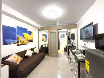 a living room with a couch and a table at Pasay MOA Manila Bay Shore Residences Dynastel Staycation 1828 in Manila