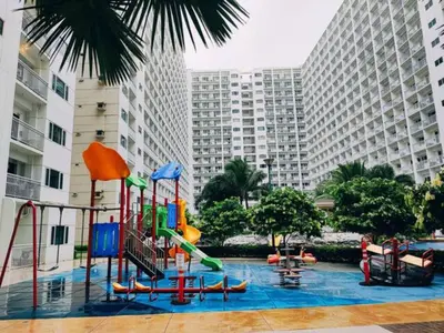 a pool with a playground in a city with tall buildings at Pasay MOA Manila Bay Shore Residences Dynastel Staycation 1828 in Manila