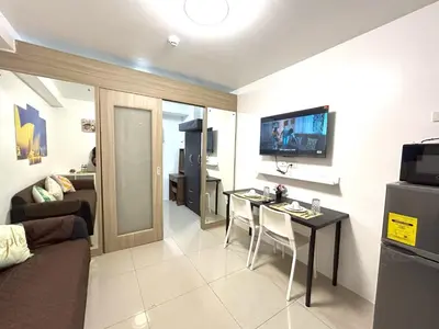 a living room with a couch and a table at Pasay MOA Manila Bay Shore Residences Dynastel Staycation 1828 in Manila