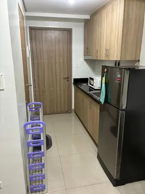 a kitchen with a black refrigerator and a blue ladder at Peaceful Pasay Getaway - Private Studio with Pool in Manila