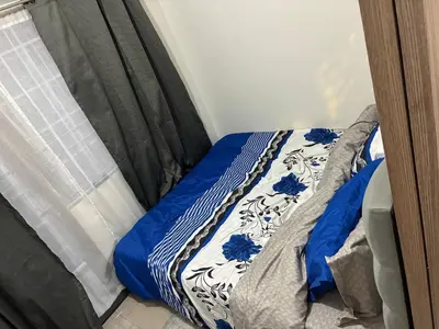a bed with a blue and white comforter in a room at Peaceful Pasay Getaway - Private Studio with Pool in Manila