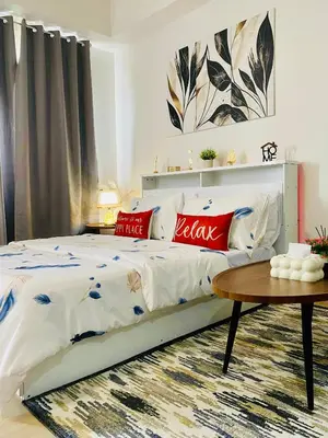 a bedroom with a bed with red pillows and a table at SMDC Park Residences Condo Unit 417 near SM City Sta Rosa in Ibaba