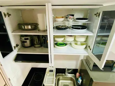 a kitchen cabinet filled with lots of dishes at SMDC Park Residences Condo Unit 417 near SM City Sta Rosa in Ibaba
