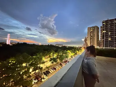 a woman standing on a balcony looking out at the city at Bay View near US Embassy, Airport in Manila