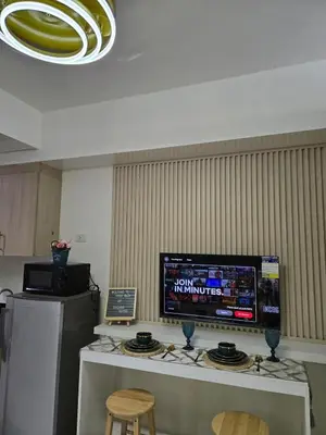 a television on a counter in a room with two chairs at Bay View near US Embassy, Airport in Manila