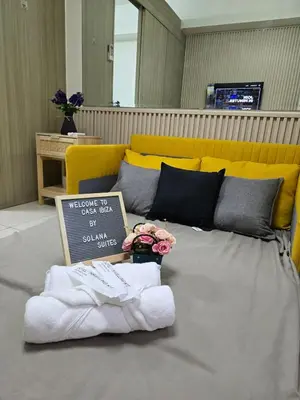 a sign sitting on top of a bed with towels at Bay View near US Embassy, Airport in Manila