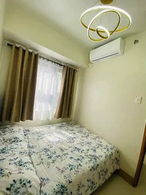 a bedroom with a bed and a window and a chandelier at Shore Residence 3 tower 1 Amenity view MOA Terminal 3 in Manila