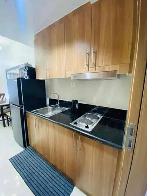 a kitchen with a sink and a black refrigerator at Shore Residence 3 tower 1 Amenity view MOA Terminal 3 in Manila