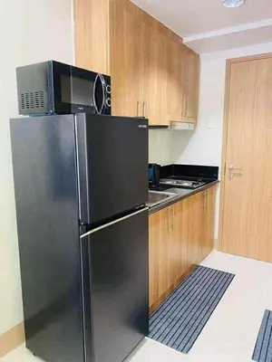a kitchen with a black refrigerator and a microwave at Shore Residence 3 tower 1 Amenity view MOA Terminal 3 in Manila