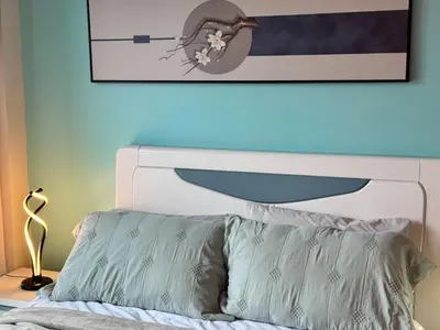 a bedroom with a bed with a picture on the wall at Uptown Parksuites Tower 2 4BR in BGC Taguig in Manila