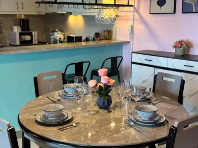 a table with plates and glasses and flowers on it at Uptown Parksuites Tower 2 4BR in BGC Taguig in Manila