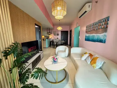 a living room with a white couch and a tv at Uptown Parksuites Tower 2 4BR in BGC Taguig in Manila