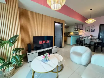 a living room with a tv and a couch and a table at Uptown Parksuites Tower 2 4BR in BGC Taguig in Manila
