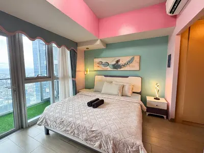 a bedroom with a bed and a large window at Uptown Parksuites Tower 2 4BR in BGC Taguig in Manila