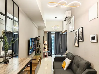 a living room with a couch and a table at Charming 1BR in Uptown Parksuites Tower 2 BGC in Manila