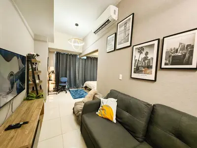 a living room with a couch in a room at Charming 1BR in Uptown Parksuites Tower 2 BGC in Manila