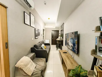 a living room with a couch and a table at Charming 1BR in Uptown Parksuites Tower 2 BGC in Manila