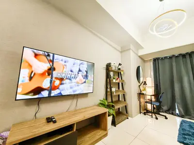 a living room with a flat screen tv on a wall at Charming 1BR in Uptown Parksuites Tower 2 BGC in Manila