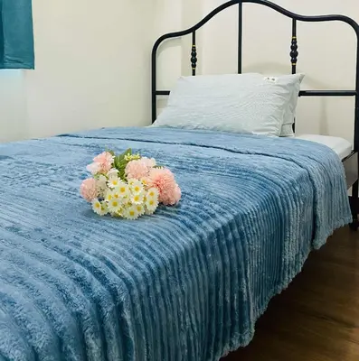 a bed with two bouquets of flowers on it at V-TAN house in Manila