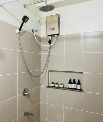 a shower with a shower head in a bathroom at V-TAN house in Manila