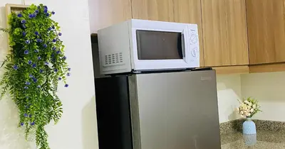 a microwave on top of a refrigerator in a kitchen at V-TAN house in Manila