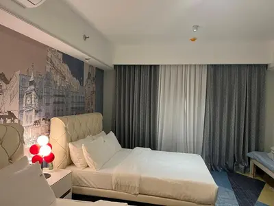 a bedroom with a white bed and a painting on the wall at East Glory PentHouse in Manila