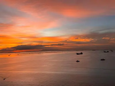 a sunset over the ocean with boats in the water at Luxury 2BR Condo Retreat Near Airports MOA Okada in Manila
