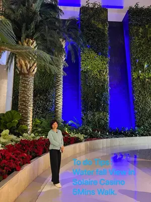 a woman standing in front of a flower display in a building at Luxury 2BR Condo Retreat Near Airports MOA Okada in Manila