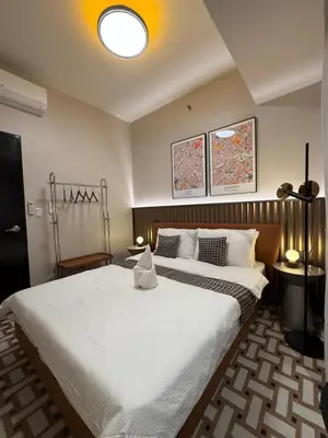 a bedroom with a large bed with white sheets at Luxury 2BR Condo Retreat Near Airports MOA Okada in Manila