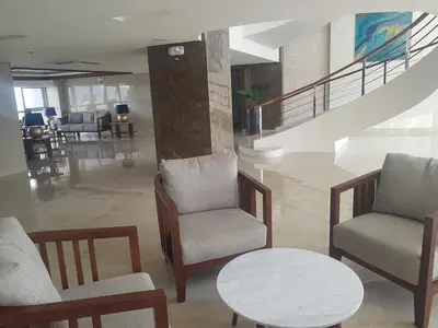 a lobby with chairs and a table and stairs at Cozy Coast Residences Pasay in Manila