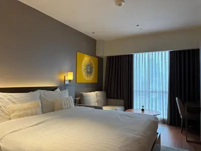 a hotel room with a large bed and a desk at The hotel residences at Acqua in Manila