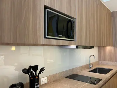 a kitchen with a microwave above a sink at The hotel residences at Acqua in Manila