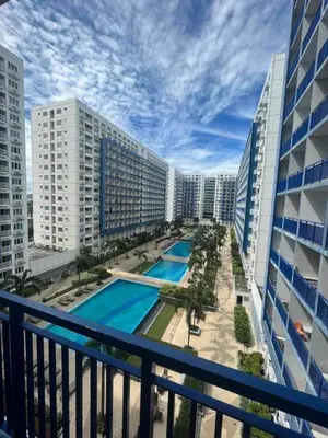 a view from a balcony of a hotel with a swimming pool at Sea Residences MOA Oasis-Nicolai Ramos in Manila