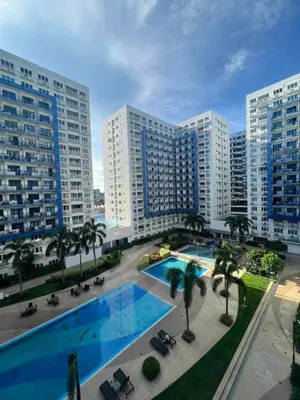 an overhead view of a pool in a city with tall buildings at Sea Residences MOA Oasis-Nicolai Ramos in Manila