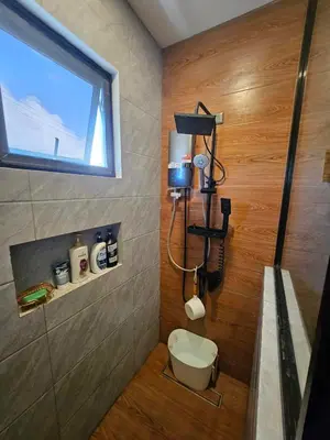 a bathroom with a shower with a toilet and a window at CASA CORAZON Spacious 4BR House Near Tagaytay for Wedding Prep Family Gatherings Reunions and Celebrations Pet Friendly and PWD Accessible in Dagatan