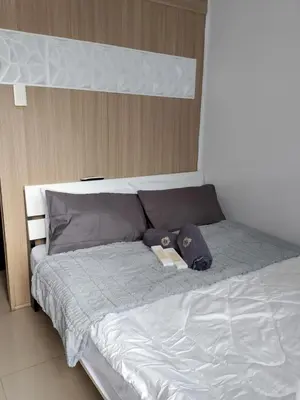 a bed with a teddy bear sitting on top of it at Staycation near MOA, Airport in Manila