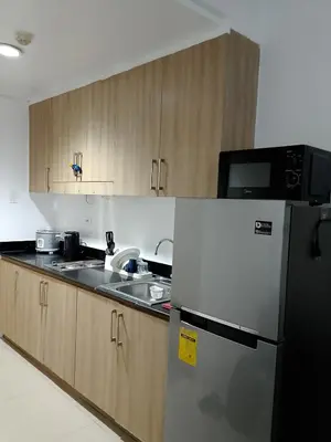 a kitchen with a refrigerator and a sink at Staycation near MOA, Airport in Manila