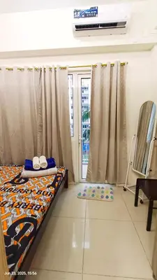 a bedroom with a bed and a sliding glass door at Shore Residences Tower D # 408 in Manila