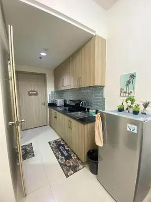 a kitchen with wooden cabinets and a stainless steel refrigerator at Shore Residences Tower D # 408 in Manila