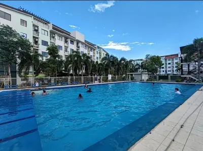 a group of people swimming in a swimming pool at El Cozy Woody Near Enchanted Kingdom in Santa Rosa